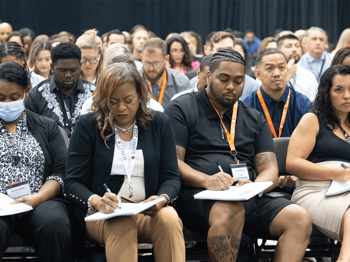 group sitting in a row writing in notebook